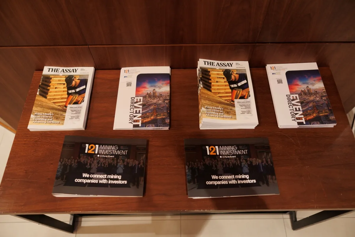 121 Mining Investment event directories and The Assay magazines displayed for attendees